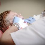 Dokter gigi memeriksa pasien di klinik