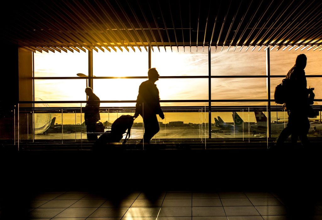 Traveler di bandara membawa koper saat perjalanan